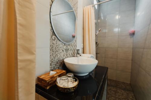 a bathroom with a sink and a mirror on a table at Dana's House in Tabanan
