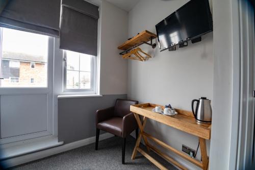 a room with a table and a chair and a window at The Bay Hotel in Pevensey