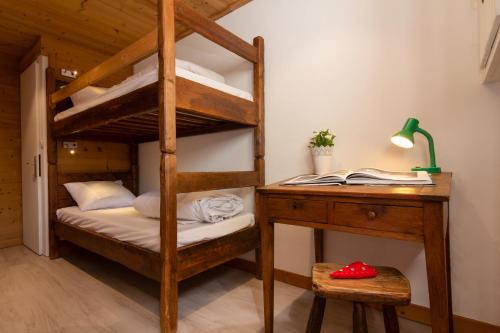 a bedroom with a bunk bed with a desk and a bunk bedouble at Chalet Dava La Via ski in - ski out - Happy Rentals in Chamonix-Mont-Blanc
