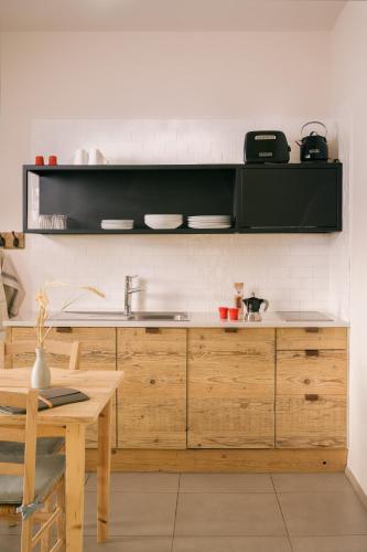 a kitchen with wooden cabinets and a sink and a table at La Darbia in Ameno