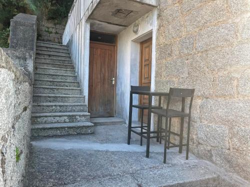 Deux chaises assises devant un bâtiment avec une porte dans l'établissement Appartement Sartène 2 personnes, à Sartène