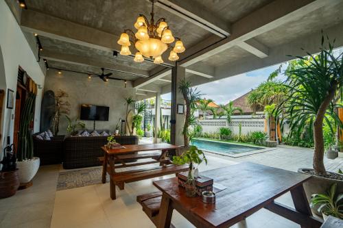 a living room with wooden furniture and a large window at The Breeze Stay and Surf Canggu Bali in Canggu