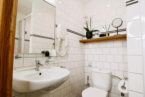a white bathroom with a sink and a toilet at Penzion Telč No. 20 in Telč