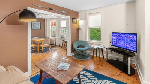 a living room with a television and a table at East end. Walk to food, beer and downtown fun. in Portland