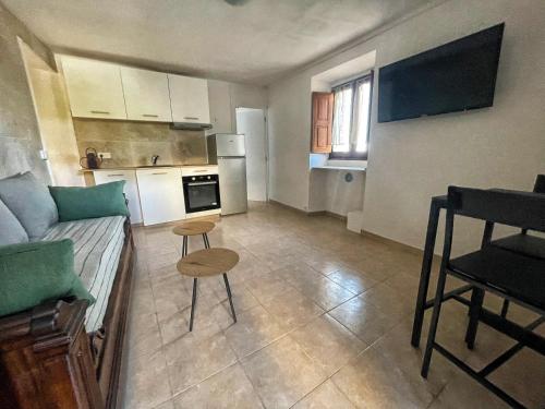 un petit salon avec un canapé et une cuisine dans l'établissement Appartement Sartène 2 personnes, à Sartène