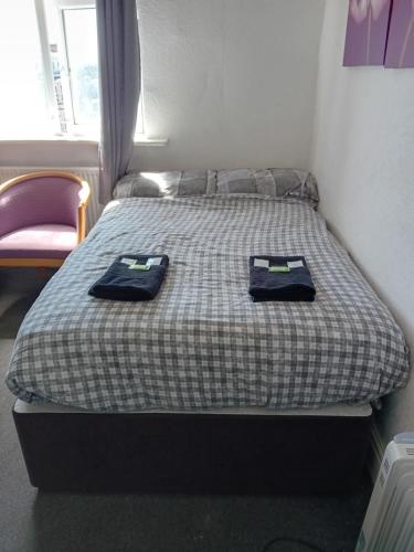a bedroom with a bed with two towels on it at The Beckwood Hotel in Blackpool