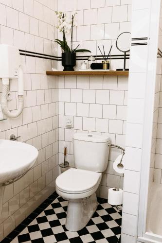 a white bathroom with a toilet and a sink at Penzion Telč No. 20 in Telč