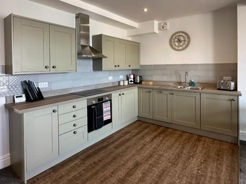 a kitchen with white cabinets and a sink at Clock Tower Apartment No4 in Morecambe