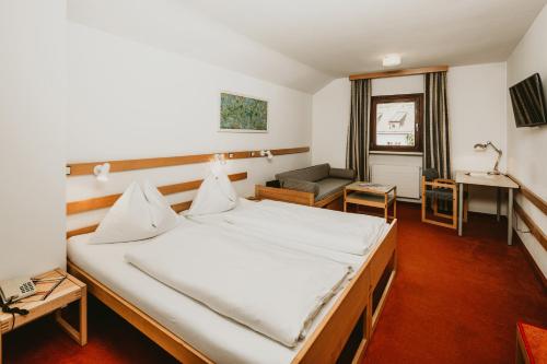 A bed or beds in a room at Hotel Kernwirt