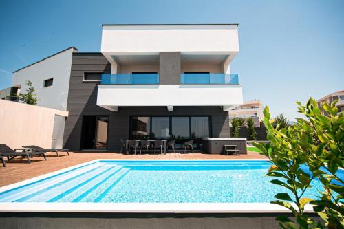 a house with a swimming pool in front of a house at Villa Primavera in Novalja