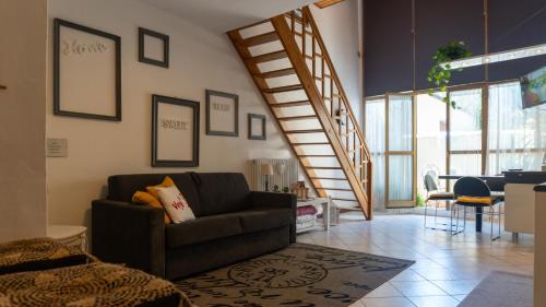 a living room with a couch and a staircase at Ol Vegè casa in centro storico in Scanzorosciate