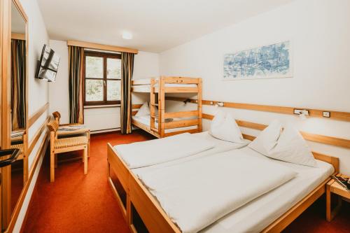 a bedroom with a bed and a bunk bed at Hotel Kernwirt in Mauterndorf