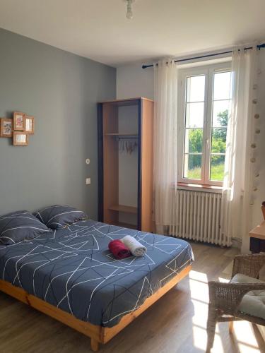 a bedroom with a bed with a blue comforter and a window at Manoir en Pierre Chartres in Chartres