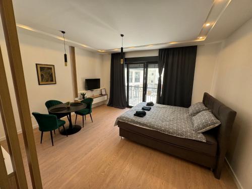 a bedroom with a bed and a table and chairs at Epicenter Suite in Trebinje