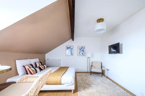 a loft bedroom with a bed and a couch at Studio confortable Anciennes écuries réhabilitée in Issy-les-Moulineaux