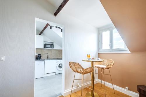 - une cuisine avec une table et deux tabourets dans une pièce dans l'établissement Studio confortable Anciennes écuries réhabilitée, à Issy-les-Moulineaux