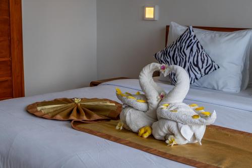 two stuffed swans are sitting on a bed at The Breeze Stay and Surf Canggu Bali in Canggu
