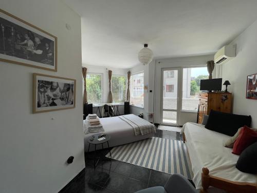 een slaapkamer met een bed en een bank in een kamer bij Modern flat near downtown Plovdiv in Plovdiv