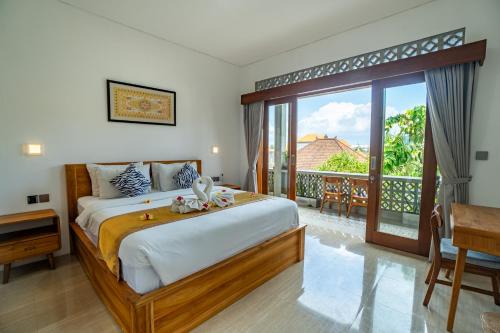 a bedroom with a large bed and a balcony at The Breeze Stay and Surf Canggu Bali in Canggu