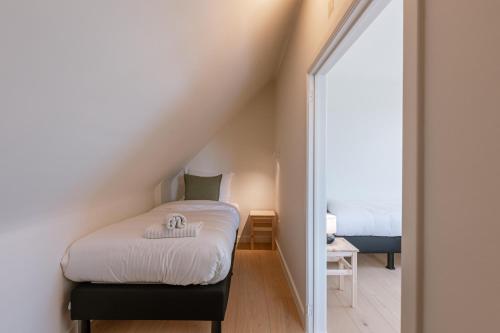 a bedroom with a bed and a mirror at Villa Camille in Sint-Idesbald