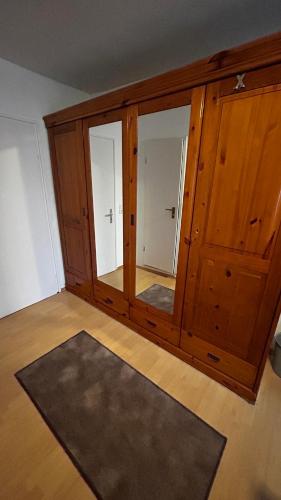 a large wooden cabinet with a mirror in a room at Gasthof Zur Post - Inning in Inning am Ammersee