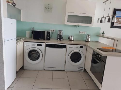 Il comprend une cuisine équipée d'un lave-linge et d'un sèche-linge. dans l'établissement Appartement spacieux à Agde avec piscine partagée 68 m², au Cap d'Agde
