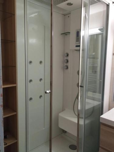 une douche avec une porte vitrée dans une salle de bain dans l'établissement Appartement spacieux à Agde avec piscine partagée 68 m², au Cap d'Agde