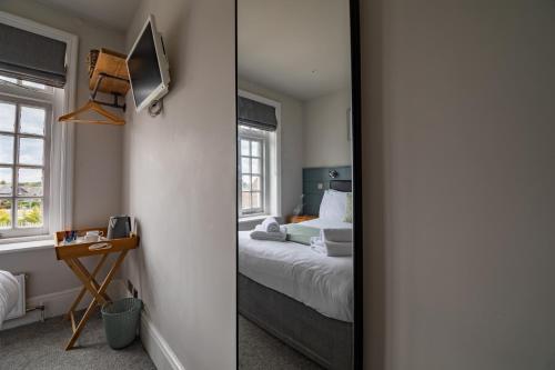 a mirror in a room with a bed at The Bay Hotel in Pevensey