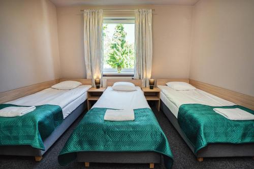 two twin beds in a room with a window at Hotel Boginia in Boginia