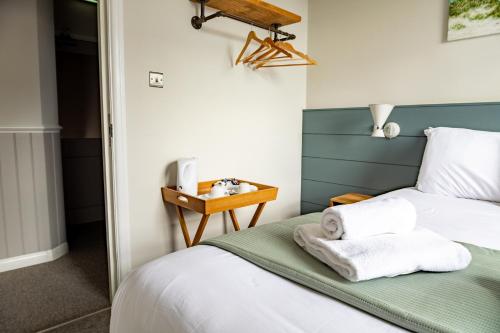 a bedroom with a bed with towels on it at The Bay Hotel in Pevensey