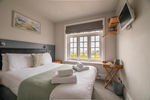 a bedroom with a bed with towels on it at The Bay Hotel in Pevensey