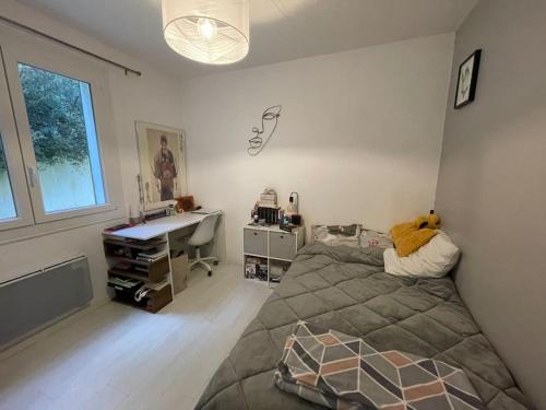 une chambre avec un lit et un bureau dans l'établissement Maison rhétaise Les Grenettes, à Sainte-Marie de Ré
