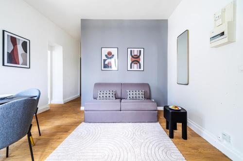 - un salon avec un canapé violet et un tapis dans l'établissement Appartement proche Paris Expo Porte de Versailles, à Issy-les-Moulineaux