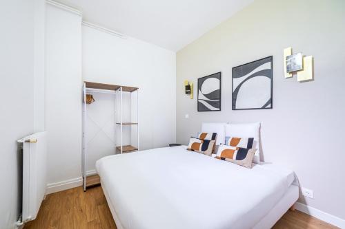 une chambre blanche avec un grand lit blanc dans l'établissement Appartement proche Paris Expo Porte de Versailles, à Issy-les-Moulineaux