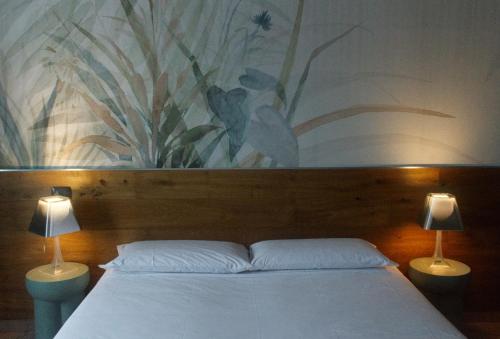 a bedroom with a bed with a painting on the wall at Locanda Da I Baldi in Laveno