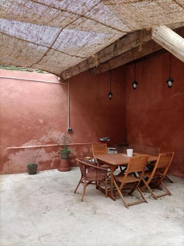 a wooden table and chairs in a patio at LE NID Appt 2 chambres Proche Pont du Gard in Remoulins