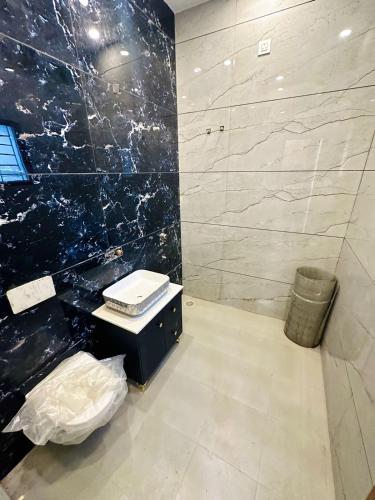 baño con lavabo y pared de mármol negro en Dev HOMESTAY VRINDAVAN, en Vrindāvan