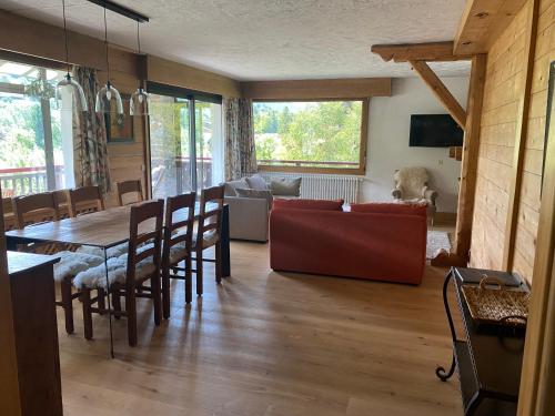 un salon avec une table et un canapé dans l'établissement appartement 103m2 près de Megève, 2 chambres, grand garage, tennis en été, à Demi-Quartier