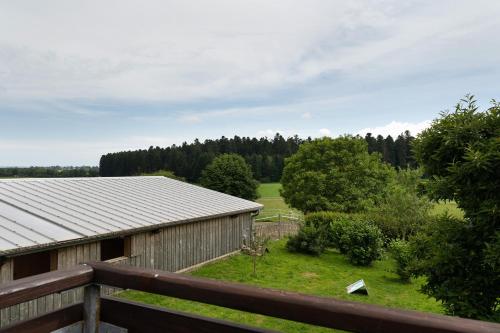 a barn with a fence and a field and trees at Fewo Naturliebe - keine Monteure in Dornhan