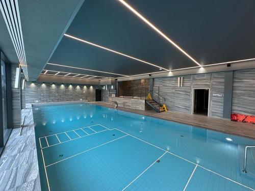 a large swimming pool in a building with at Baltic Comfort SPA Apartment - FREE swimming pool, saunas & fitness - Kasprowicza 20 in Kołobrzeg
