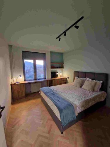 sypialnia z dużym łóżkiem i dużym oknem w obiekcie DS apartment w mieście Bitola