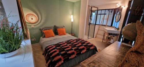 - une chambre avec un lit doté d'oreillers orange et d'un miroir dans l'établissement Charmante maison de famille près de Lyon, à Lozanne