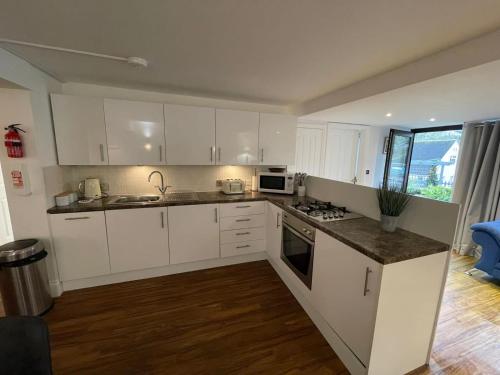 a kitchen with white cabinets and a counter top at No1 Apartment Mevagissey in Mevagissey