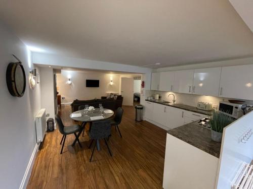 a kitchen and a living room with a table and chairs at No1 Apartment Mevagissey in Mevagissey