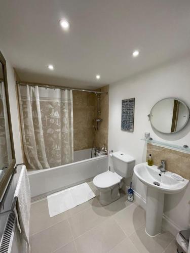 a bathroom with a sink and a toilet and a tub at No1 Apartment Mevagissey in Mevagissey