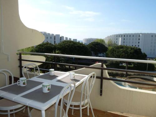 une table et des chaises sur un balcon avec vue dans l'établissement Studio cabine, piscine, proche plage et commerces - FR-1-328-219, à La Grande Motte