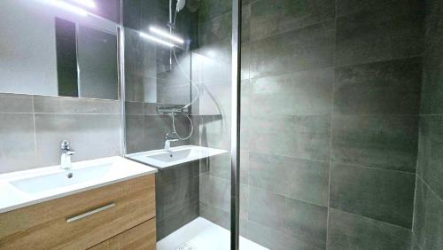 a bathroom with a shower and a sink and a mirror at Appartement cosy 1 chambre 4 pers face pistes 09 in LʼHuez
