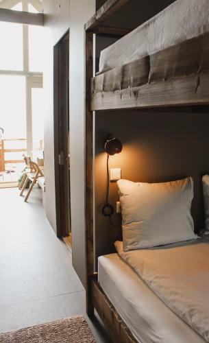 a bedroom with a bunk bed with a lamp on it at Strandhuisjes Zoomers aan Zee in Castricum