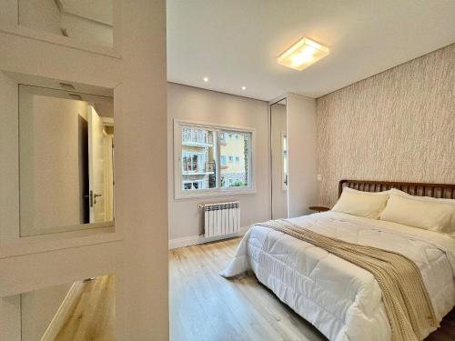 Un dormitorio con una cama grande y una ventana. en Casa de Pedra 2 Suítes e Piscina by Achei Gramado, en Gramado
