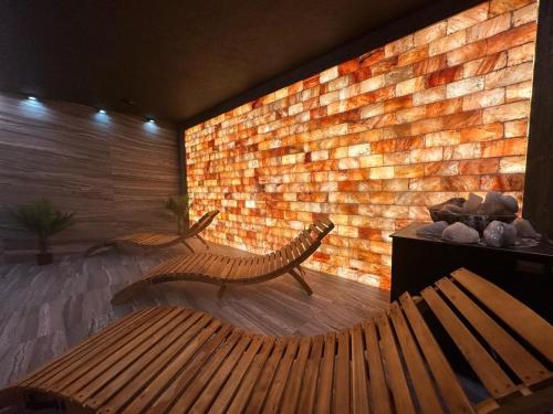 a bench in a room with a brick wall at Baltic Comfort SPA Apartment - FREE swimming pool, saunas & fitness - Kasprowicza 20 in Kołobrzeg